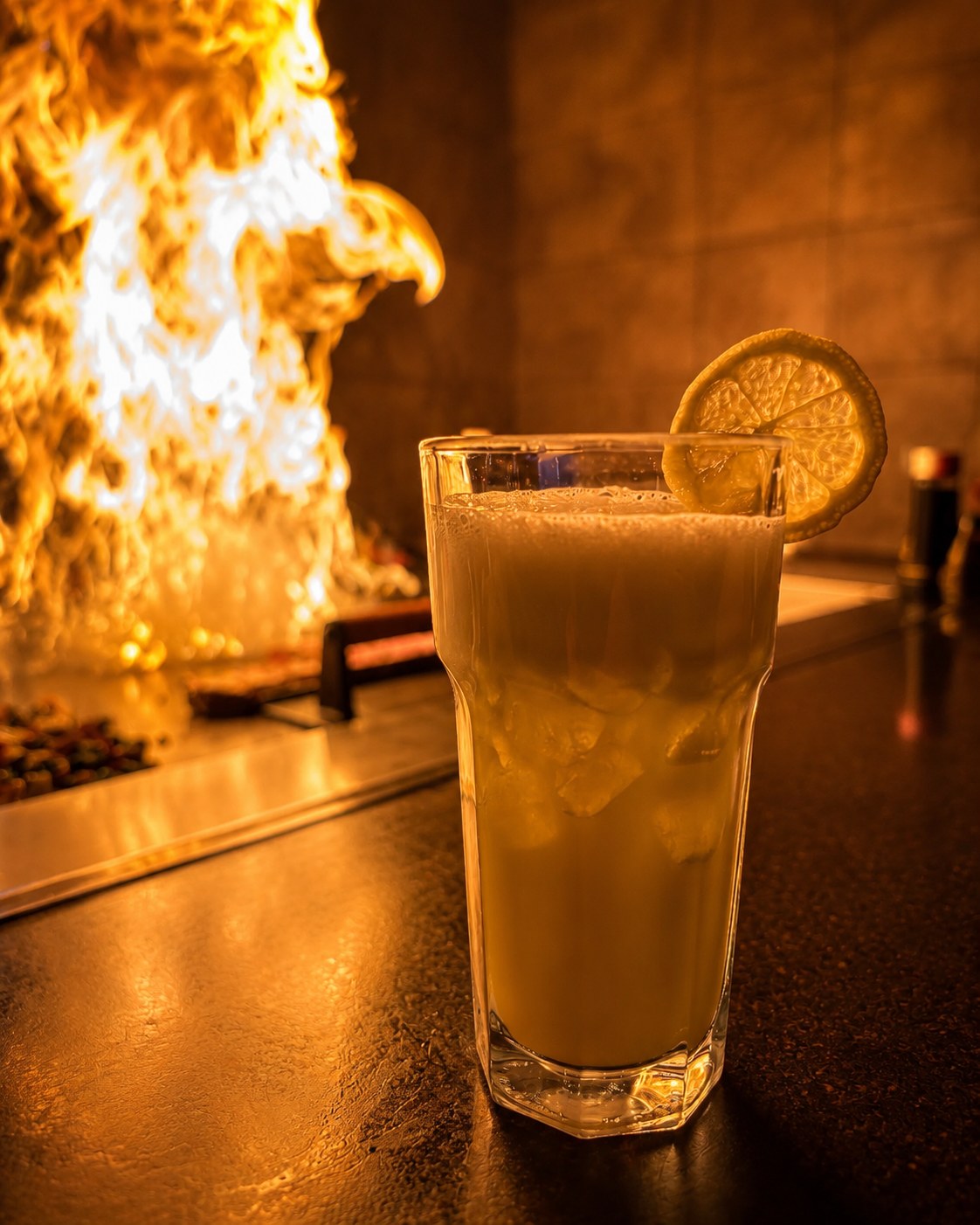 Citrus cocktail beside a flaming Suehiro hibachi grill