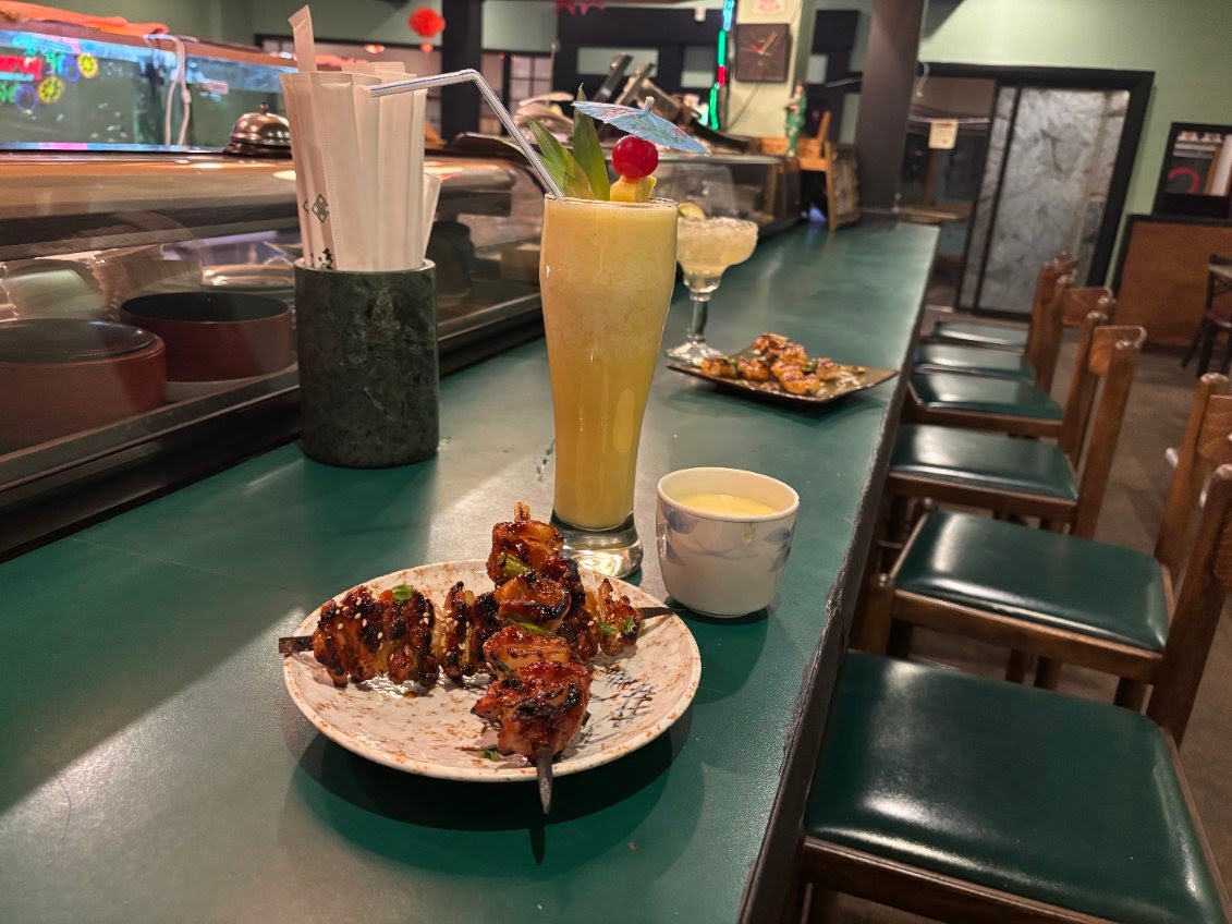 Warmly lit Suehiro bar with yakitori, tropical drinks, and traditional Japanese decor