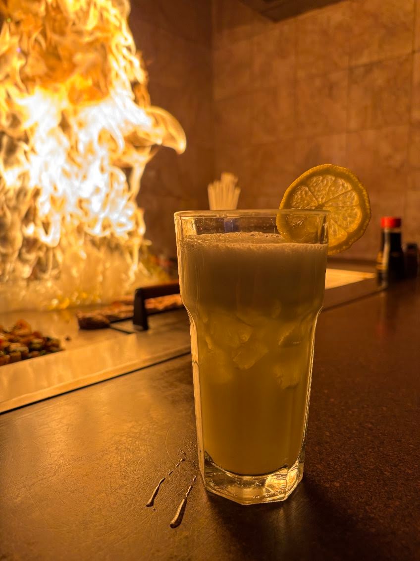 Cocktail beside a dramatic hibachi flame at the grill